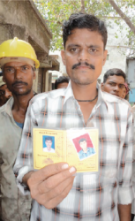 血液型が記載された組合員証を見せるムンバイの労働者
